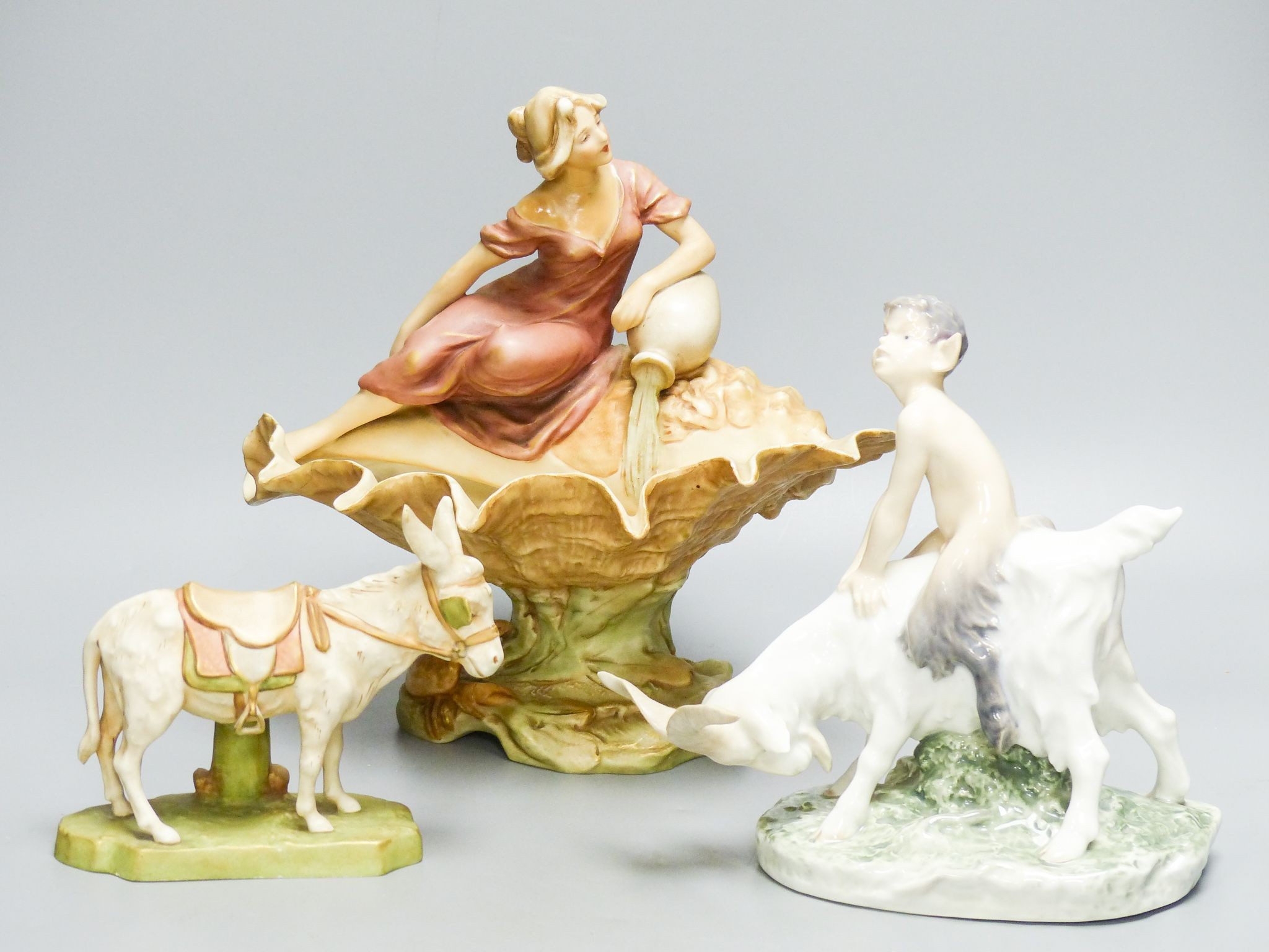 A Royal Dux figural dish, 26cm high and a figure of a donkey and a Royal Copenhagen group of a faun riding a goat, 22cm long